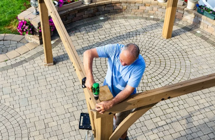 Person baut Holzkonstruktion mit Akkuschrauber